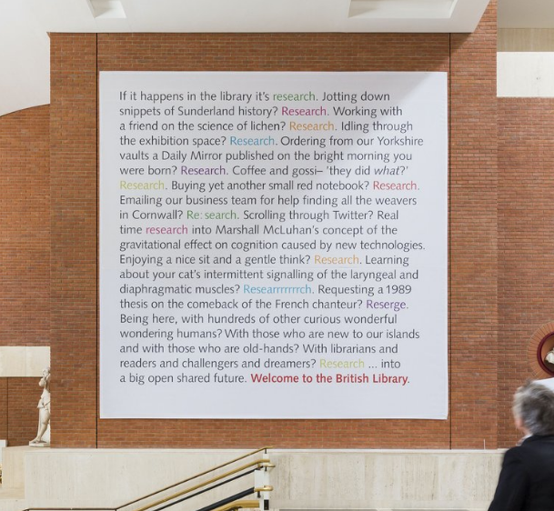 A large printed advert inside the British Museum saying 'If it happens in the library it's research. Jotting down snippets of Sunderland's history? Research. Working with a friend on the science of lichen? Research. Idling through the exhibition space? Research. Ordering from our Yorkshire vaults a Daily Mirror published on the bright morning you were born? Research. Coffee and gossi- 'they did what?' Research. Buying yet another small red notebook? Research. Emailing our business team for help finding all the weavers in Cornwall? Re: search. Scrolling through Twitter? Real time researching into Marshall McLuhan's concept of the gravitational effect on cognition caused by new technologies. Enjoying a nice sit and a gentle think? Research. Learning about your cat's intermittent signalling of the laryngeal and diaphragmatic muscles? Researrrrrrch. Requesting a 1989 thesis on the comeback of the French chanteur? Reserge. Being here, with hundreds of other curious wonderful wondering humans? With those who are new to our islands and with those who are old hands? With librarians and readers and challengers and dreamers? Research...into a big open shared future. Welcome to the British Library.