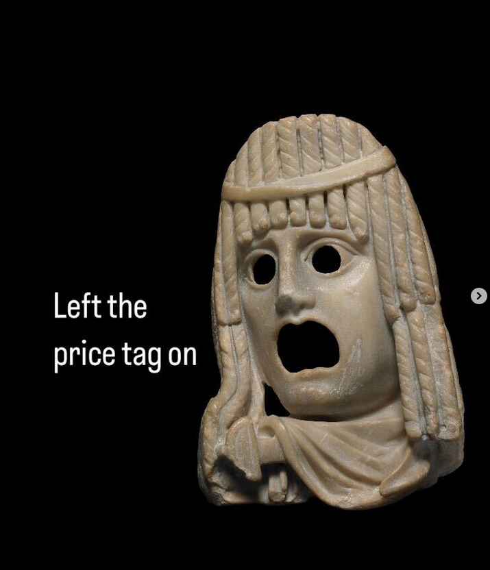 A picture of a sculpture of a Greek theatrical mask with mouth wide open, with the text 'Left the price tag on' written next to it.